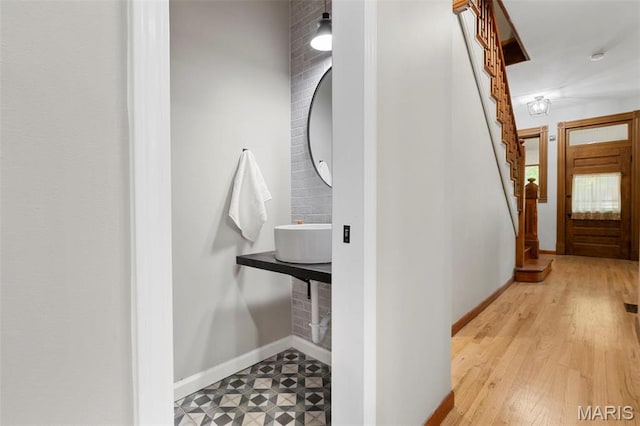 corridor with stairway, baseboards, and wood finished floors