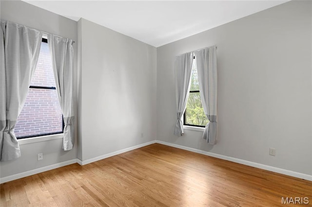 unfurnished room featuring light wood finished floors and baseboards