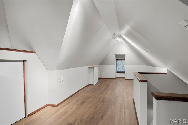bonus room featuring light wood finished floors, lofted ceiling, and baseboards