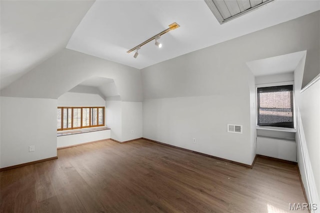 bonus room with wood finished floors, baseboards, and vaulted ceiling
