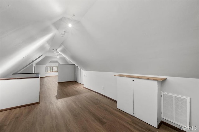 bonus room with vaulted ceiling, wood finished floors, and baseboards
