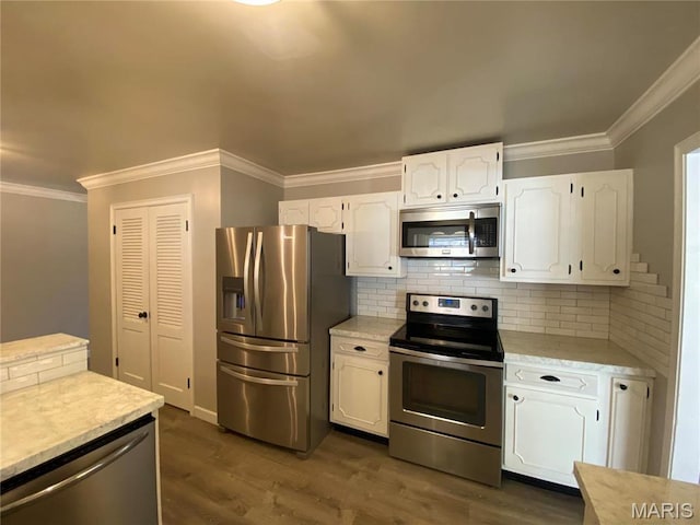 2 El Rancho Dr, Hannibal, MO 63401 - kitchen with appliances with stainless steel finishes, white cabinetry, light countertops, dark wood-style floors, and crown molding