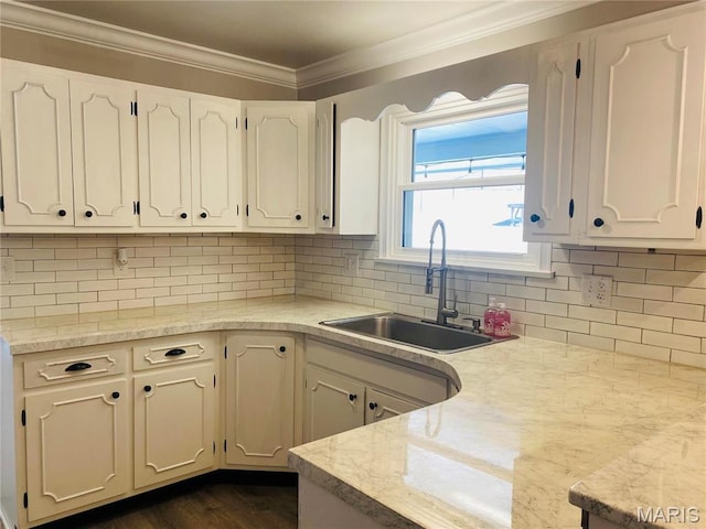 2 El Rancho Dr, Hannibal, MO 63401 - kitchen with a sink, crown molding, white cabinets, light countertops, and backsplash