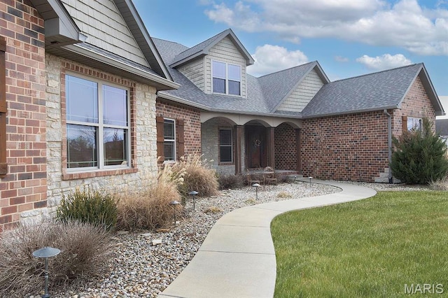 9606 Klings Ct, Mascoutah, IL 62258 - view of exterior entry featuring brick siding, roof with shingles, and a lawn
