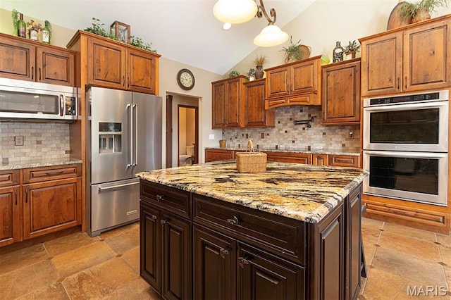 9606 Klings Ct, Mascoutah, IL 62258 - kitchen featuring stainless steel appliances, lofted ceiling, backsplash, stone tile flooring, and a kitchen island