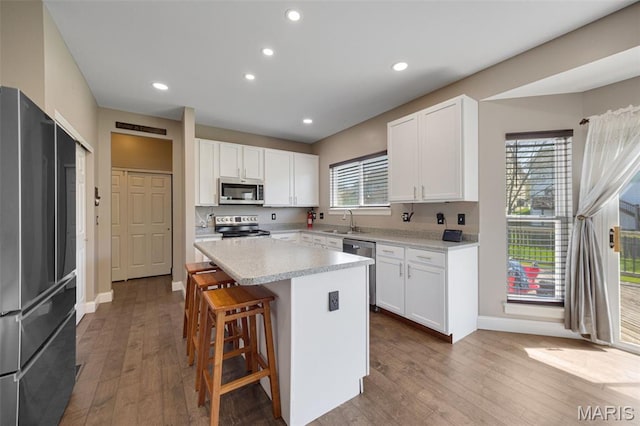 1218 Cold Spring Dr, Ofallon, MO 63368 - kitchen with appliances with stainless steel finishes, a sink, baseboards, light countertops, and dark wood-type flooring