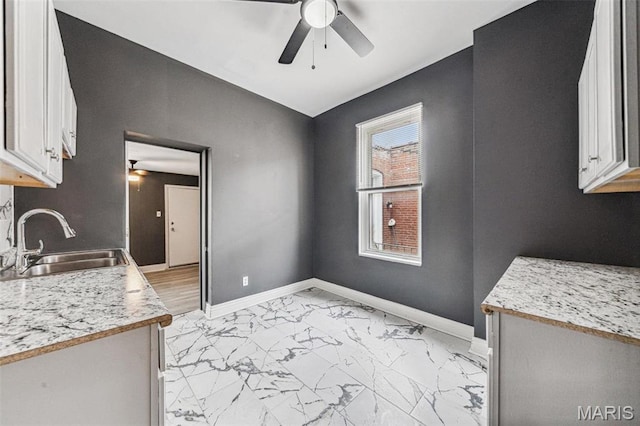 4649 Louisiana Ave, Saint Louis, MO 63111 - kitchen with a ceiling fan, a sink, light marble finish floors, light countertops, and white cabinets