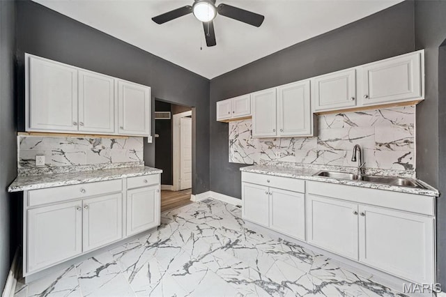 4649 Louisiana Ave, Saint Louis, MO 63111 - kitchen featuring a sink, light marble finish flooring, a ceiling fan, baseboards, and tasteful backsplash
