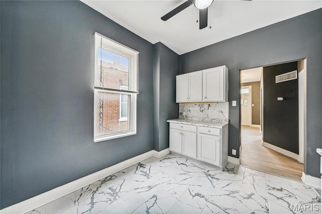 4649 Louisiana Ave, Saint Louis, MO 63111 - kitchen featuring light marble finish floors, ceiling fan, baseboards, and white cabinets