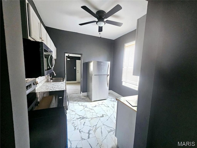 4649 Louisiana Ave, Saint Louis, MO 63111 - kitchen featuring appliances with stainless steel finishes, a sink, light marble finish floors, ceiling fan, and light countertops