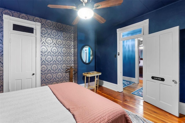 34 N Fountain Cpe, Girardeau, MO 63701 - bedroom featuring hardwood / wood-style flooring, baseboards, wallpapered walls, an accent wall, and ceiling fan