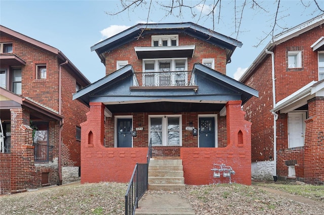 view of front of home with a balcony and brick siding