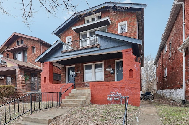 view of front of home featuring a balcony, brick siding, and a porch