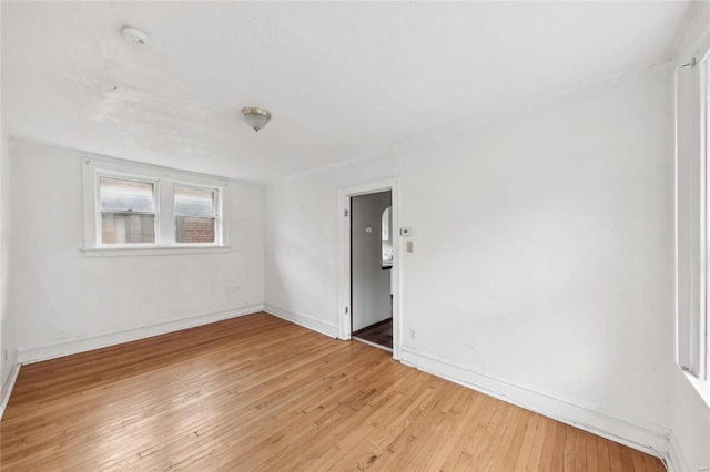 spare room with light wood-type flooring and baseboards