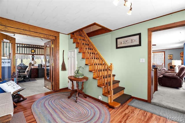 staircase with baseboards and wood finished floors