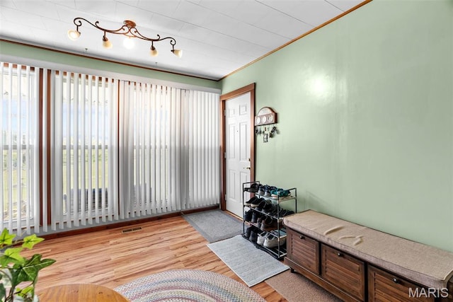interior space featuring light wood-style flooring and crown molding