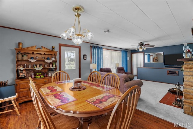 dining space with a ceiling fan, wood finished floors, and a chandelier