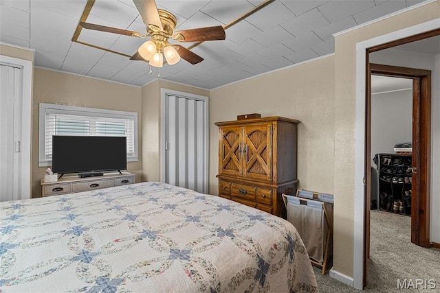 bedroom featuring carpet, ornamental molding, and a ceiling fan