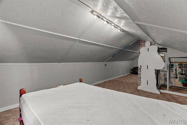 carpeted bedroom with a textured ceiling, baseboards, and lofted ceiling