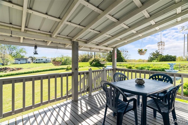 deck featuring outdoor dining area and a yard