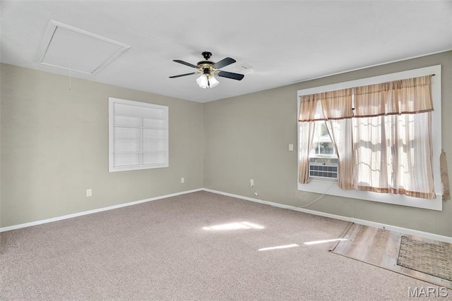 empty room featuring baseboards, carpet floors, a ceiling fan, and attic access
