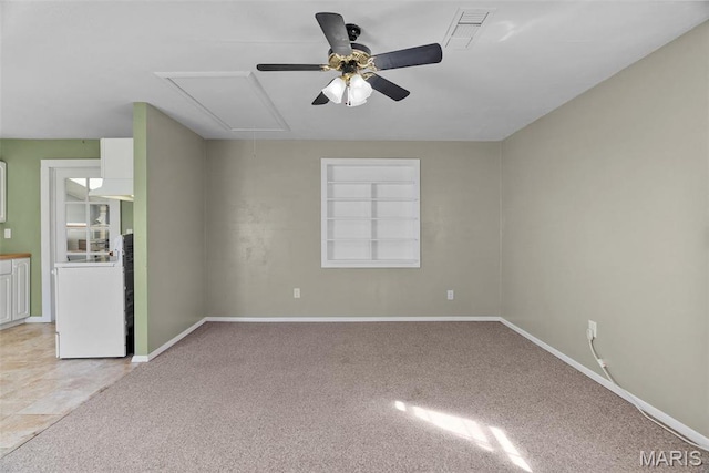 unfurnished room featuring attic access, ceiling fan, light carpet, and baseboards