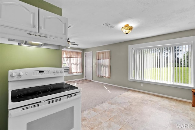 kitchen featuring white range with electric stovetop, under cabinet range hood, a ceiling fan, and baseboards