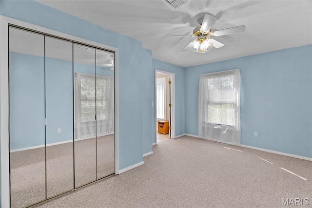 unfurnished bedroom with multiple windows, baseboards, carpet floors, and a closet