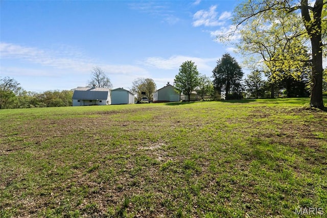 view of green lawn with a pole building and an outdoor structure