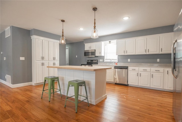 601 Broadway St, Van Buren, MO 63965 - kitchen featuring appliances with stainless steel finishes, white cabinetry, light countertops, light wood-style floors, and recessed lighting