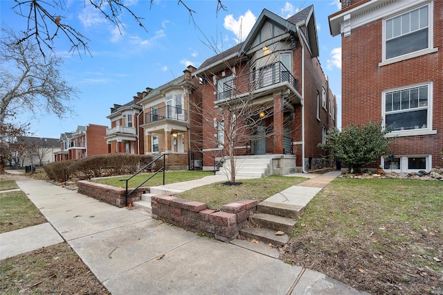 5818 Westminster Pl, Saint Louis, MO 63112 - view of front facade with a balcony, brick siding, a front lawn, and a residential view