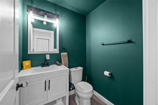 5818 Westminster Pl, Saint Louis, MO 63112 - bathroom with toilet, vanity, baseboards, and wood finished floors