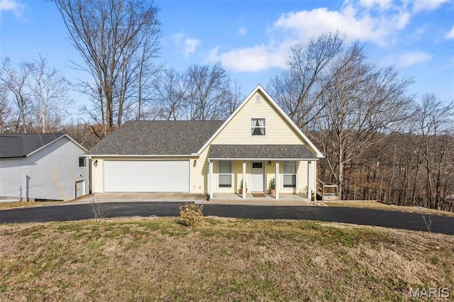 1451 Bella Vista Dr, Jackson, MO 63755 - view of front facade featuring covered porch, asphalt driveway, an attached garage, and a front lawn