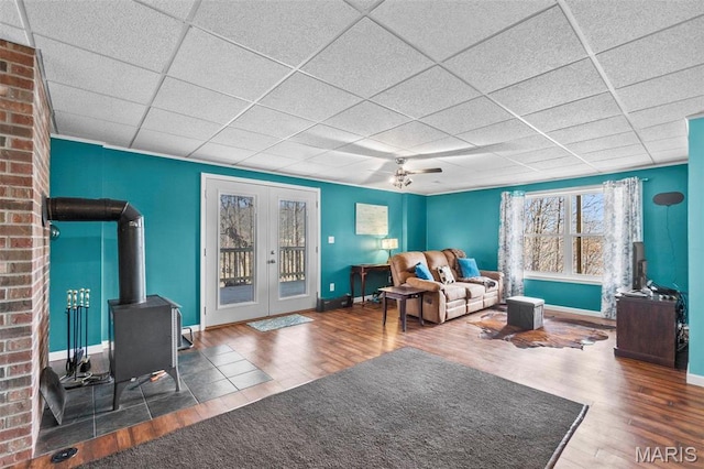 1451 Bella Vista Dr, Jackson, MO 63755 - living room featuring a wood stove, wood finished floors, a paneled ceiling, french doors, and baseboards
