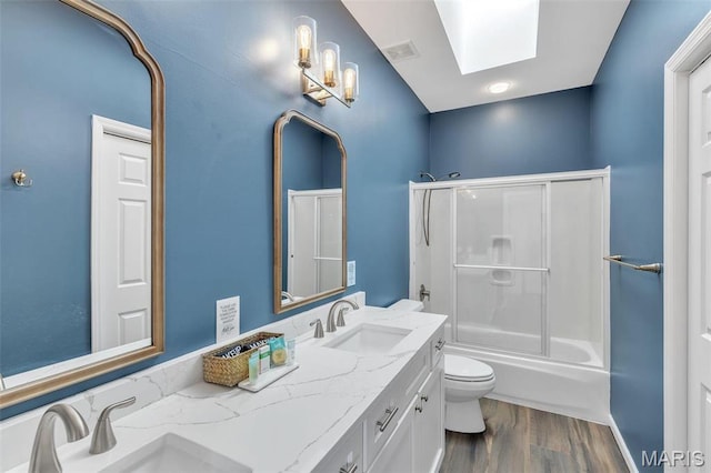 3560 Saint Albans Rd, Saint Albans, MO 63073 - bathroom featuring toilet, double vanity, a skylight, wood finished floors, and enclosed tub / shower combo