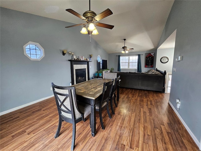 19782 Sugar Ln, Waynesville, MO 65583 - dining room with a ceiling fan, wood finished floors, a tile fireplace, baseboards, and vaulted ceiling