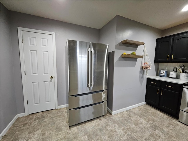19782 Sugar Ln, Waynesville, MO 65583 - kitchen featuring freestanding refrigerator, baseboards, dark cabinets, open shelves, and backsplash