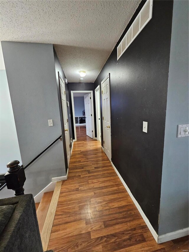 19782 Sugar Ln, Waynesville, MO 65583 - hallway with wood finished floors, baseboards, a textured ceiling, and stairway