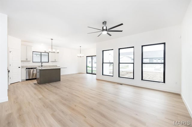 905 Montebello Ln, Ofallon, IL 62269 - unfurnished living room with a chandelier, a ceiling fan, light wood-style flooring, and baseboards