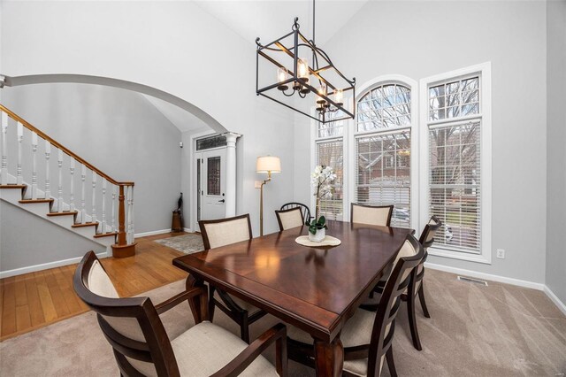 dining area with plenty of natural light, high vaulted ceiling, arched walkways, and baseboards