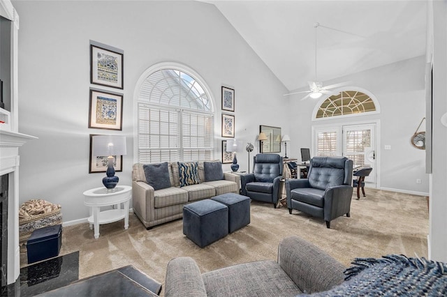 living room featuring high vaulted ceiling, baseboards, carpet floors, a fireplace, and a ceiling fan