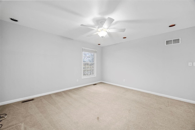 carpeted spare room with ceiling fan and baseboards