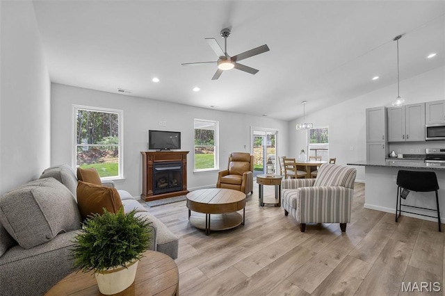 1569 Hickory Lndg, De Soto, MO 63020 - living area featuring light wood-style flooring, vaulted ceiling, healthy amount of natural light, a fireplace, and a ceiling fan