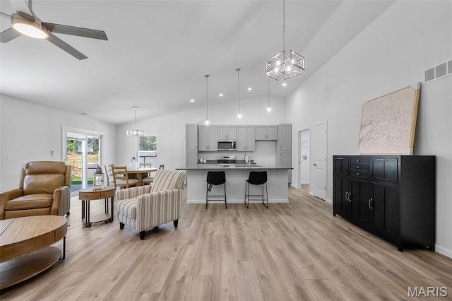 1569 Hickory Lndg, De Soto, MO 63020 - living area with a chandelier, light wood finished floors, a ceiling fan, high vaulted ceiling, and recessed lighting