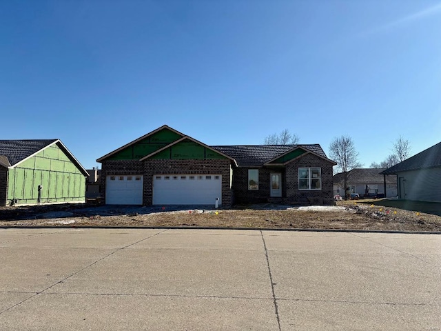 view of front of house featuring brick siding, a garage, and driveway