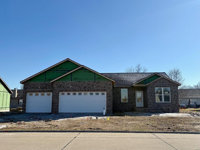 view of front facade featuring brick siding, a garage, and driveway