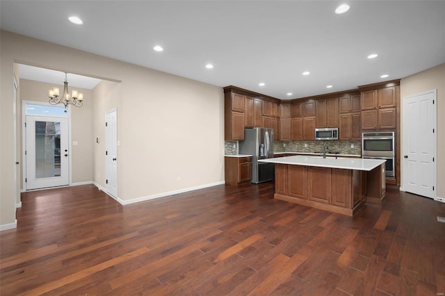 4036 Hempstead St, Saint Charles, MO 63301 - kitchen featuring stainless steel appliances, light countertops, a chandelier, decorative backsplash, and dark wood-style floors