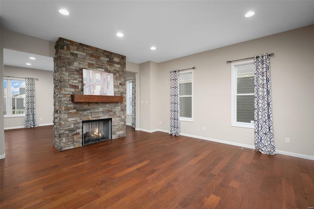 4036 Hempstead St, Saint Charles, MO 63301 - unfurnished living room featuring wood finished floors, baseboards, a stone fireplace, plenty of natural light, and recessed lighting