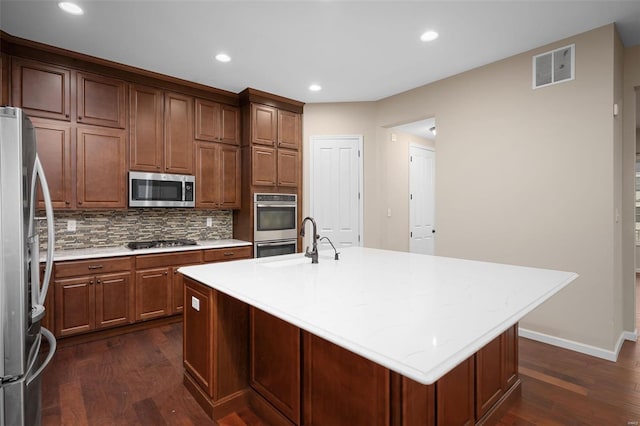 4036 Hempstead St, Saint Charles, MO 63301 - kitchen with stainless steel appliances, dark wood-style floors, decorative backsplash, recessed lighting, and a kitchen island with sink