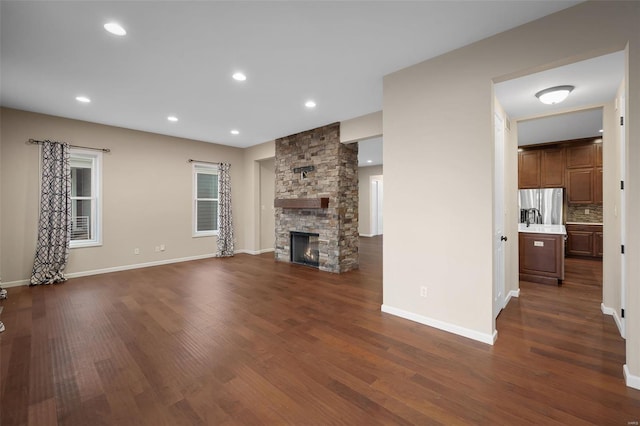 4036 Hempstead St, Saint Charles, MO 63301 - unfurnished living room featuring dark wood finished floors, a stone fireplace, baseboards, and recessed lighting